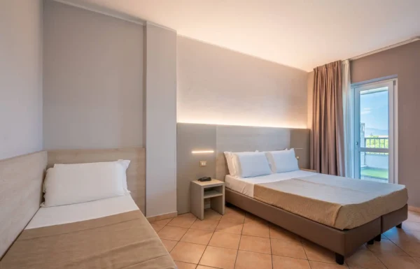 Camera d'albergo con letto matrimoniale e singolo.