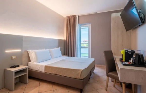 Camera d'albergo moderna con letto matrimoniale e scrivania.