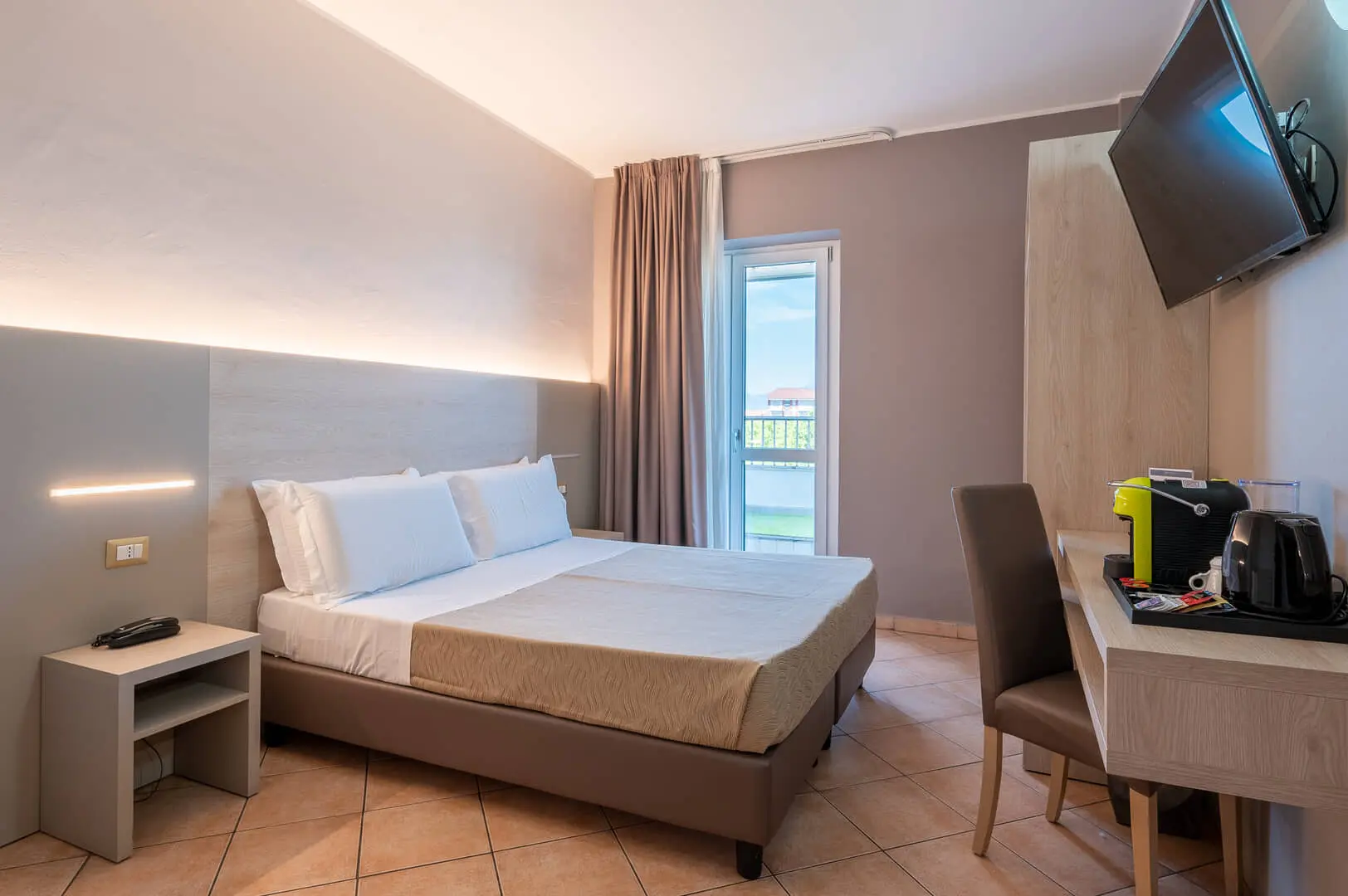 Camera d'albergo moderna con letto matrimoniale e scrivania.