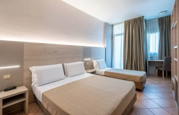 Camera d'hotel con letto matrimoniale e singolo.