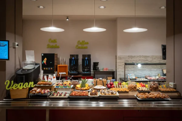 Buffet con opzioni vegan e angolo caffè.