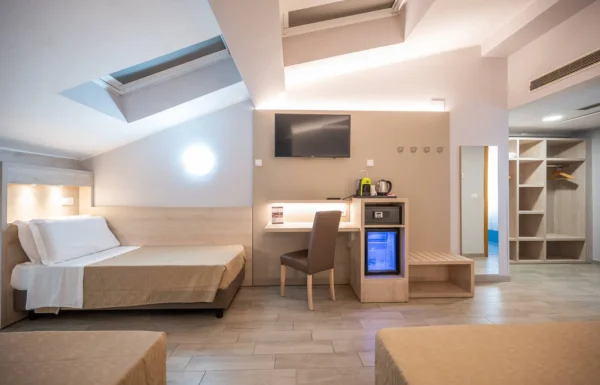 Camera d'albergo moderna con letto e scrivania.