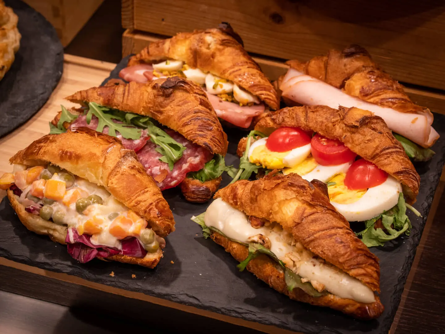 Croissant salati su un vassoio con vari ripieni.