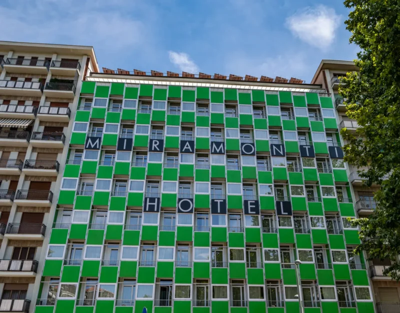 Facciata colorata dell'hotel Miramonti con cielo azzurro.